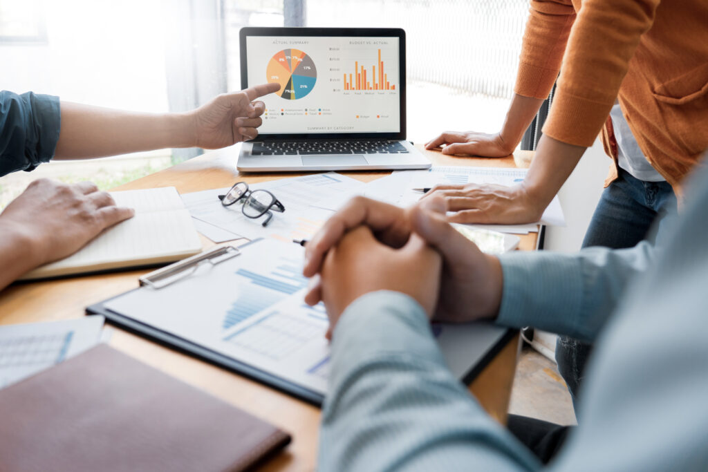 team of marketers reviewing graphs showing results of SEO vs PPC advertising efforts.