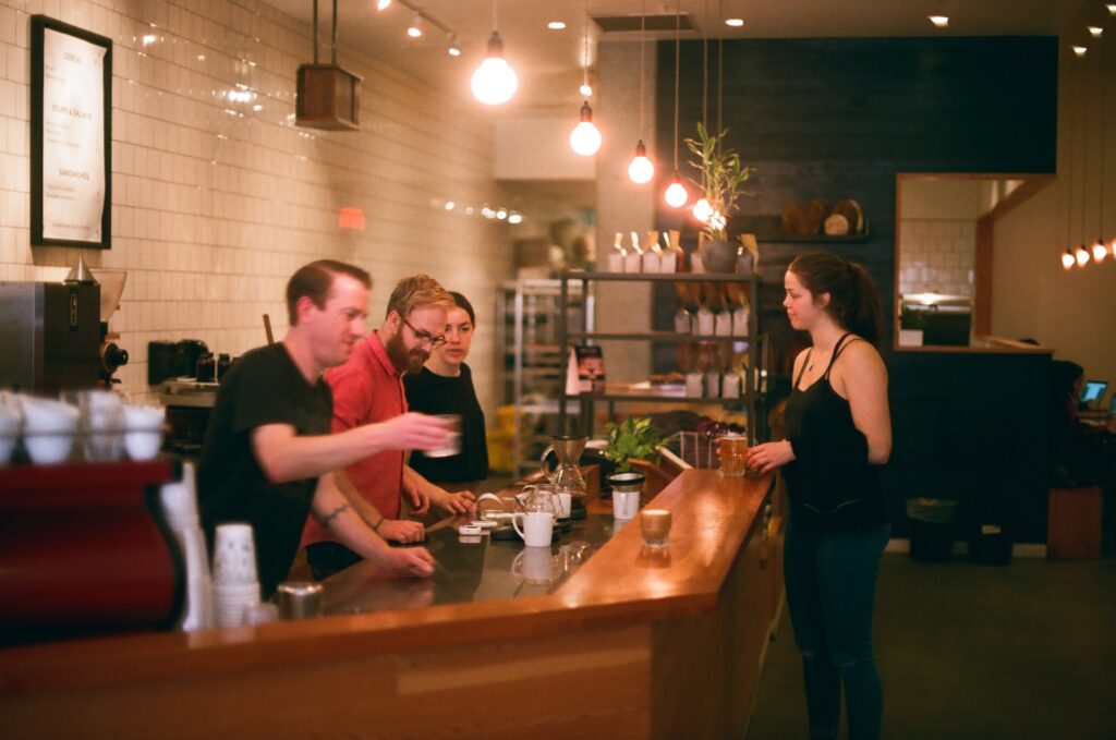 small business owner of a coffee shop serving a drink to a customer